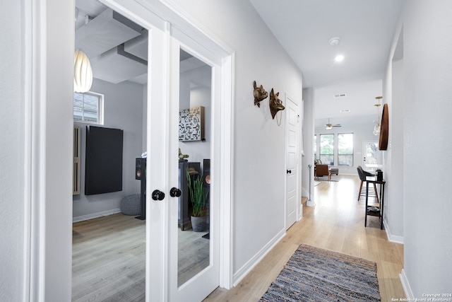 corridor featuring french doors and light wood-type flooring