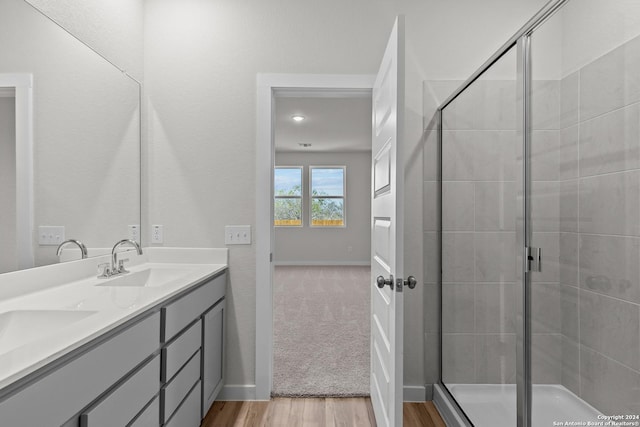 bathroom with hardwood / wood-style flooring, vanity, and an enclosed shower