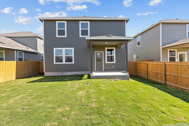 rear view of house featuring a lawn