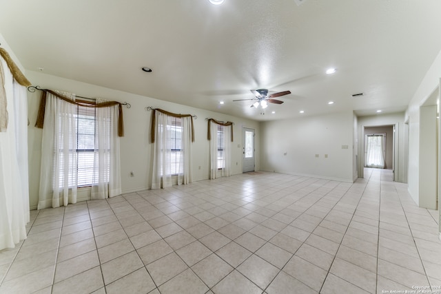 unfurnished living room with ceiling fan and light tile patterned flooring