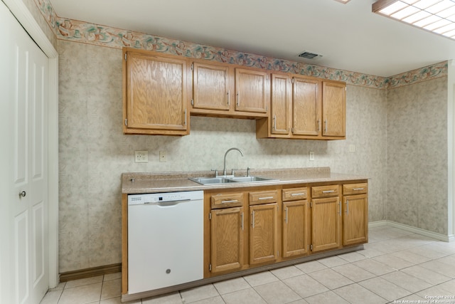 kitchen featuring white dishwasher, light tile patterned floors, and sink