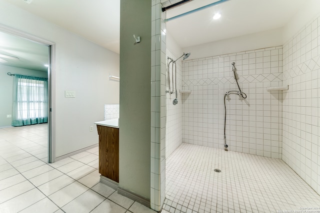 bathroom with tile patterned floors, vanity, and a tile shower