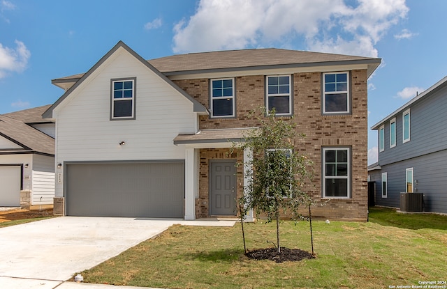 view of front of property featuring central air condition unit, a garage, and a front yard