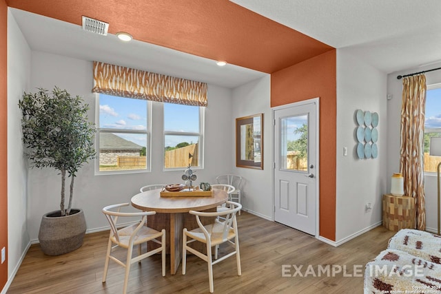 dining room featuring light hardwood / wood-style floors and a textured ceiling