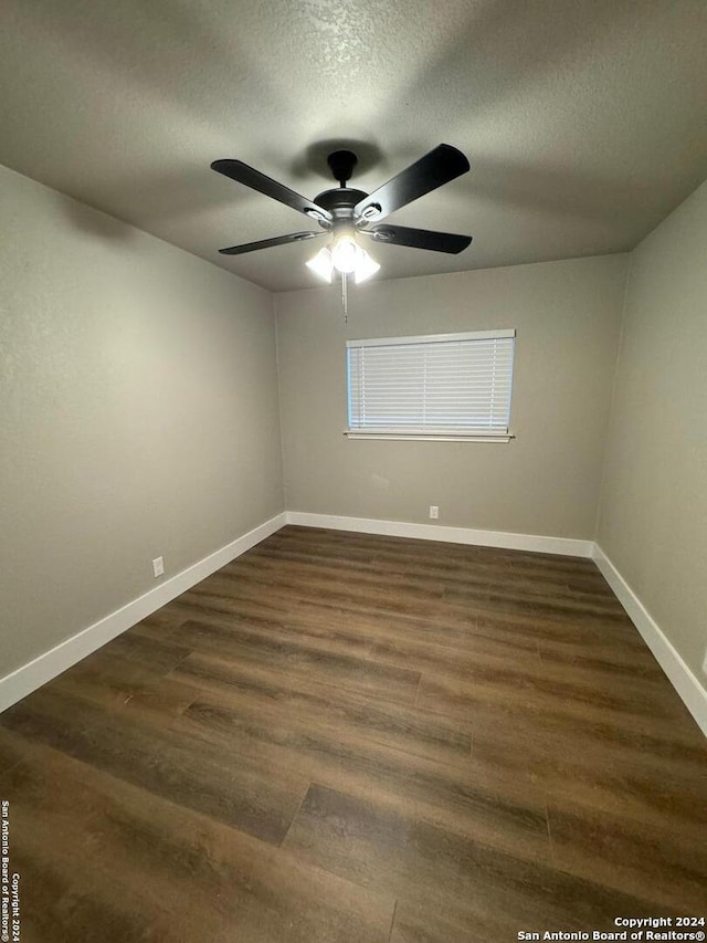 unfurnished room with ceiling fan, dark hardwood / wood-style flooring, and a textured ceiling