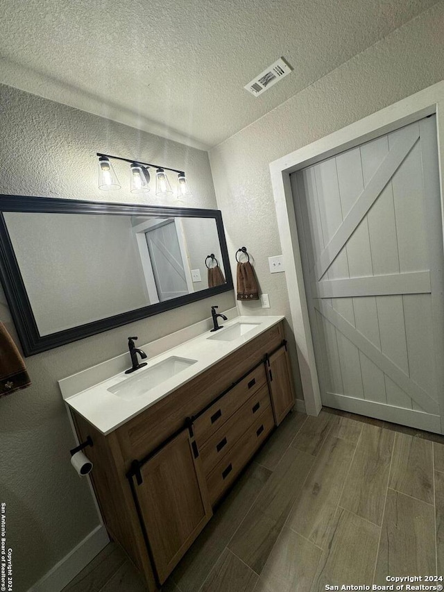 bathroom featuring a textured ceiling, vanity, and hardwood / wood-style flooring