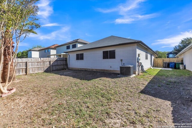 back of property featuring a yard and central AC unit