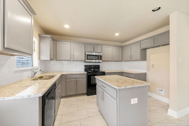 kitchen with black appliances, a kitchen island, gray cabinets, sink, and decorative backsplash