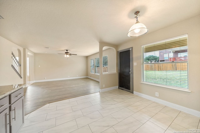 interior space featuring a textured ceiling, ceiling fan, and light hardwood / wood-style flooring