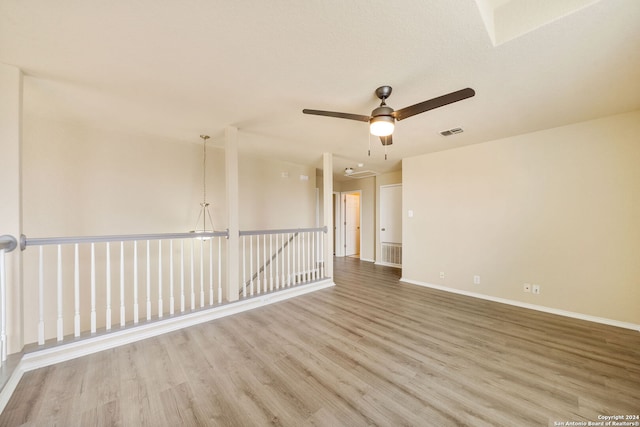 spare room featuring hardwood / wood-style floors and a notable chandelier