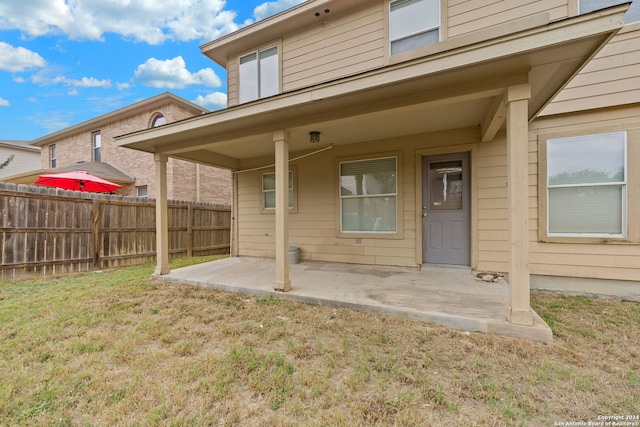 back of property with a lawn and a patio area