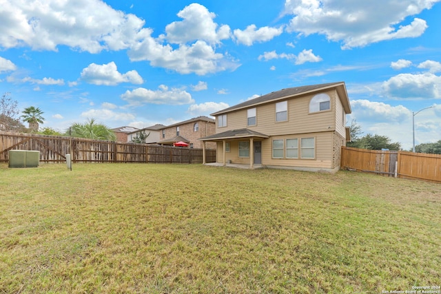 rear view of property featuring a patio and a yard