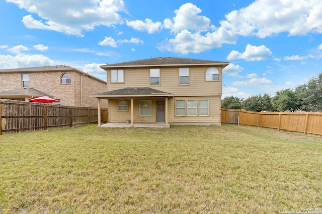 back of property with a yard and a patio area