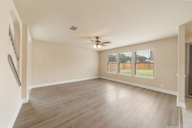 unfurnished room with light hardwood / wood-style floors, a textured ceiling, and ceiling fan