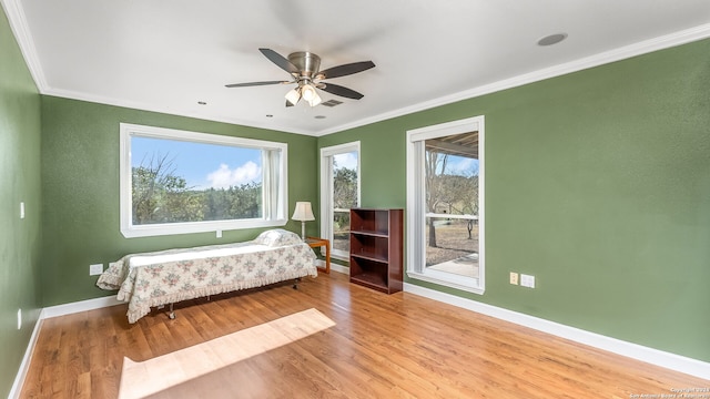 bedroom with ornamental molding, ceiling fan, and light hardwood / wood-style flooring