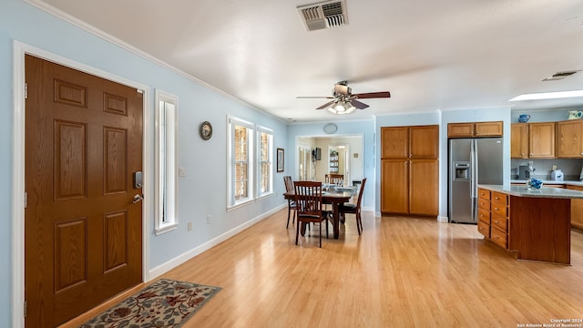 dining space featuring ceiling fan, ornamental molding, and light hardwood / wood-style flooring