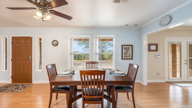 dining space featuring light wood-type flooring, ceiling fan, and crown molding