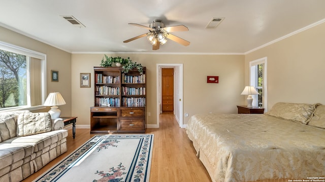 bedroom with light hardwood / wood-style floors, ceiling fan, and crown molding