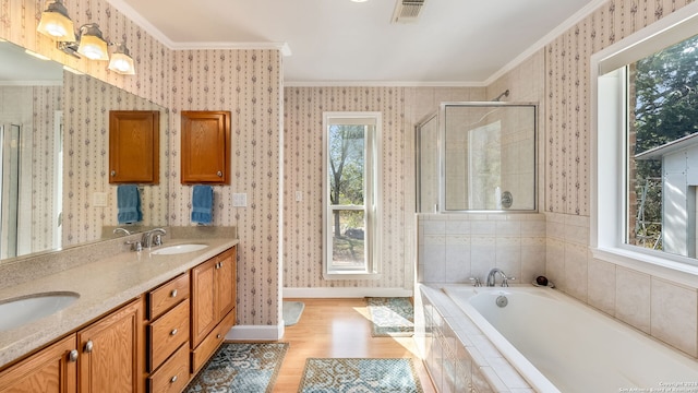 bathroom with wood-type flooring, independent shower and bath, crown molding, and vanity