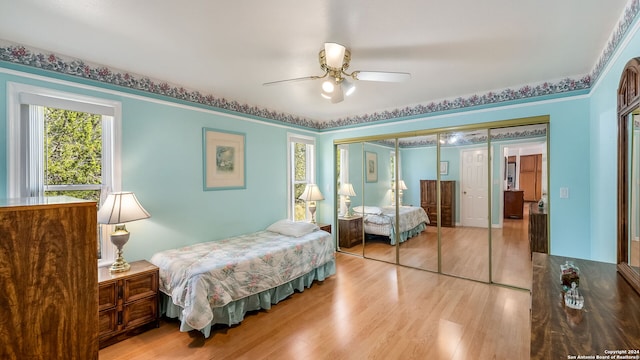 bedroom featuring a closet, light wood-type flooring, and ceiling fan