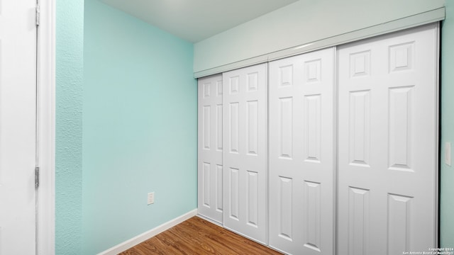 unfurnished bedroom featuring hardwood / wood-style floors and a closet