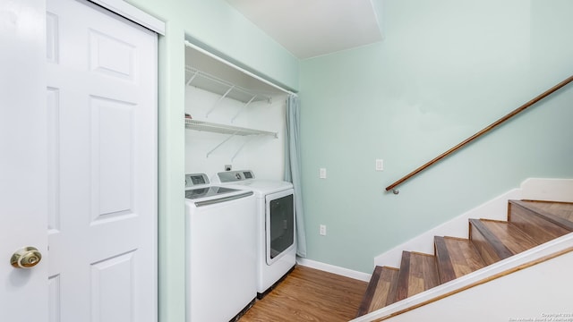 laundry area with wood-type flooring and separate washer and dryer