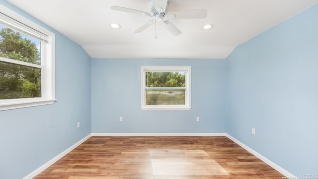 unfurnished room featuring light wood-type flooring, plenty of natural light, and lofted ceiling