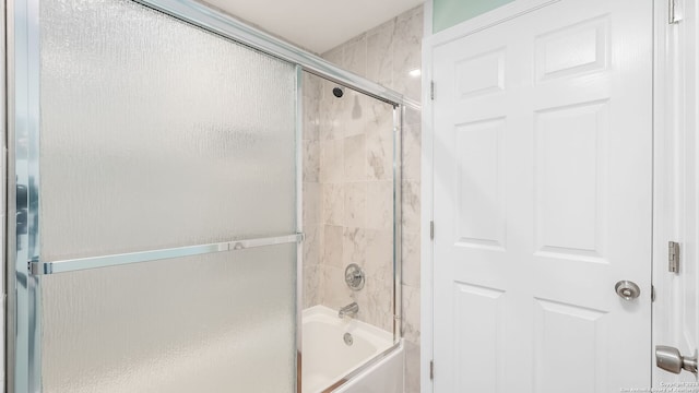 bathroom with combined bath / shower with glass door