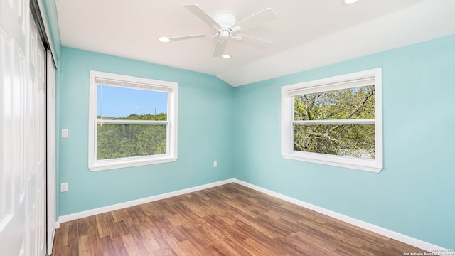 empty room with hardwood / wood-style flooring, ceiling fan, and lofted ceiling