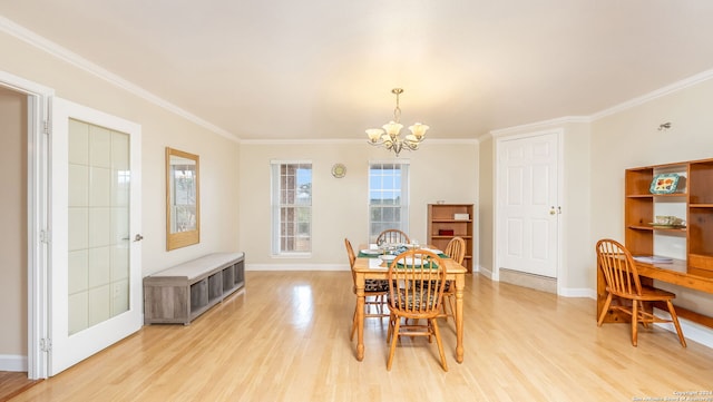 dining area featuring light hardwood / wood-style floors, crown molding, and an inviting chandelier