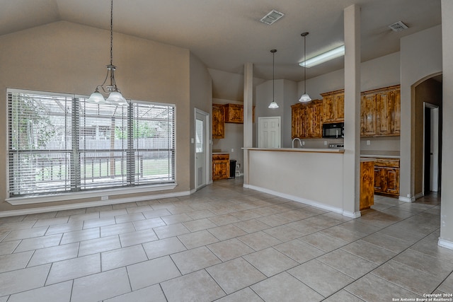 kitchen featuring a chandelier, plenty of natural light, light tile patterned floors, and pendant lighting