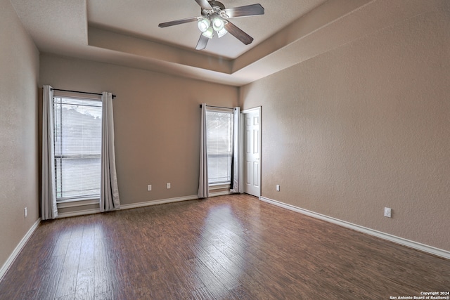 unfurnished room featuring ceiling fan, dark hardwood / wood-style floors, and plenty of natural light