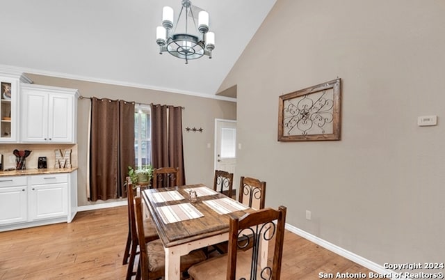 dining space with high vaulted ceiling, a chandelier, and light hardwood / wood-style floors