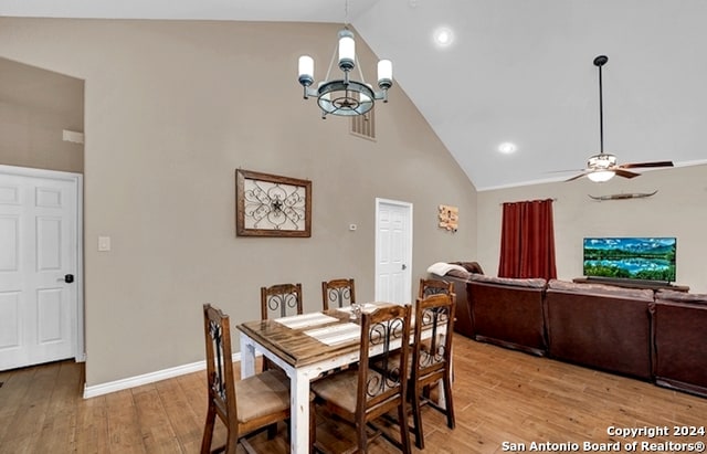 dining area featuring high vaulted ceiling, light hardwood / wood-style floors, and ceiling fan with notable chandelier