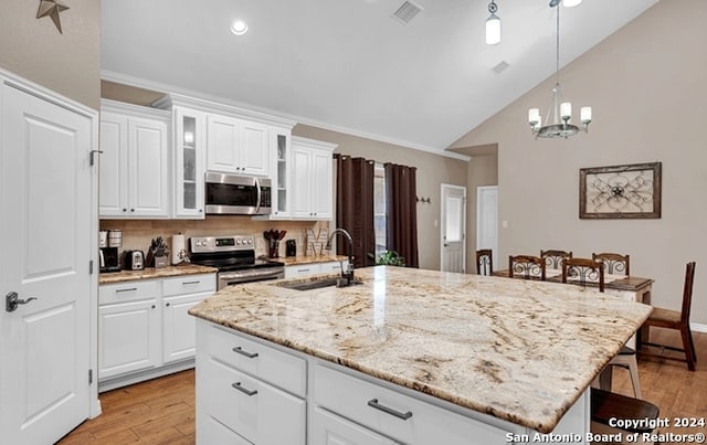 kitchen with appliances with stainless steel finishes, sink, white cabinets, lofted ceiling, and light hardwood / wood-style flooring