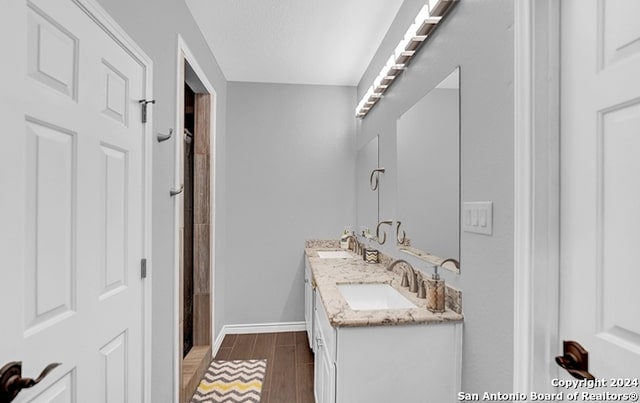 bathroom featuring walk in shower, vanity, and hardwood / wood-style floors