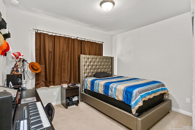 bedroom featuring a textured ceiling and light carpet