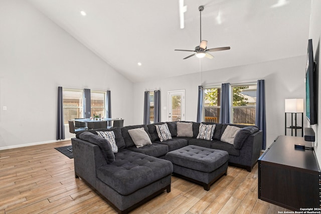 living room with light wood-type flooring, ceiling fan, and high vaulted ceiling