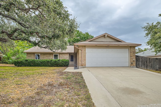 ranch-style home featuring a garage and a front lawn