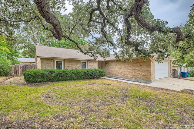 ranch-style house featuring a garage and a front yard