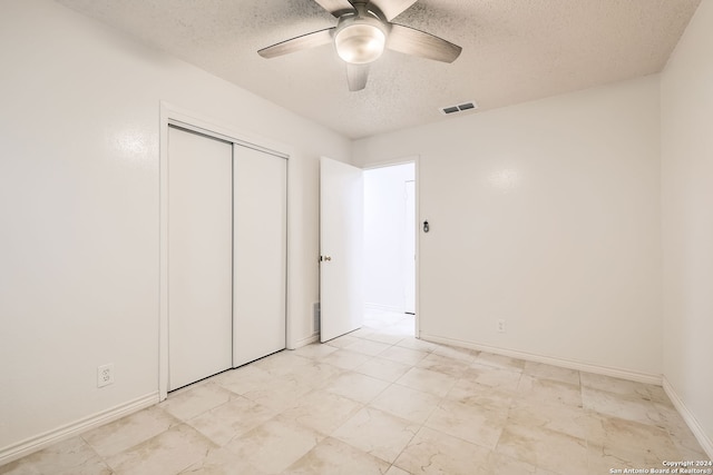 unfurnished bedroom featuring ceiling fan, a closet, and a textured ceiling