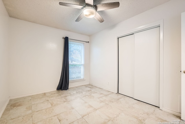 unfurnished bedroom with ceiling fan, a closet, and a textured ceiling