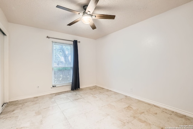 spare room with a textured ceiling and ceiling fan