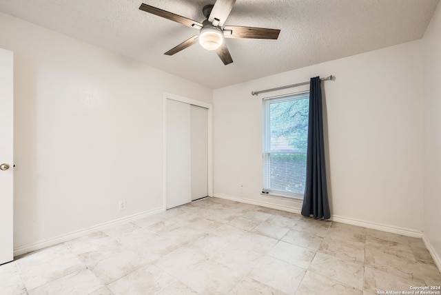 empty room featuring ceiling fan and a textured ceiling