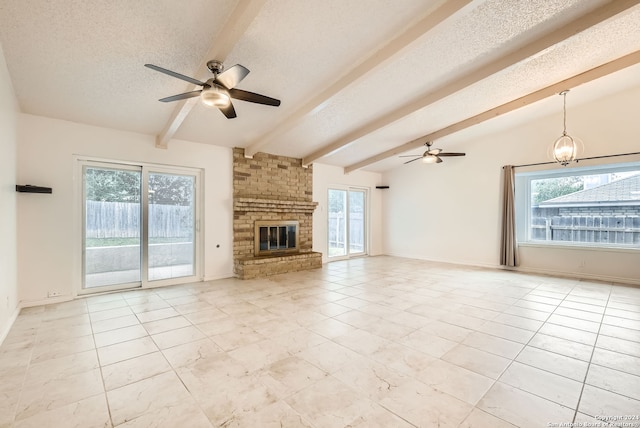 unfurnished living room with vaulted ceiling with beams, ceiling fan, a fireplace, and a healthy amount of sunlight