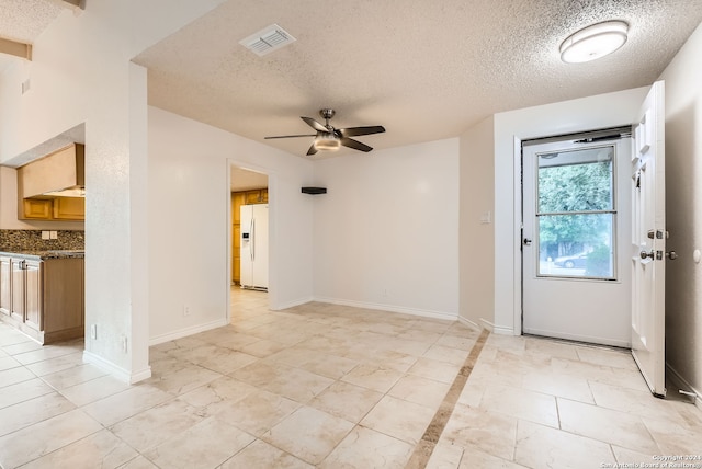 entryway with ceiling fan and a textured ceiling