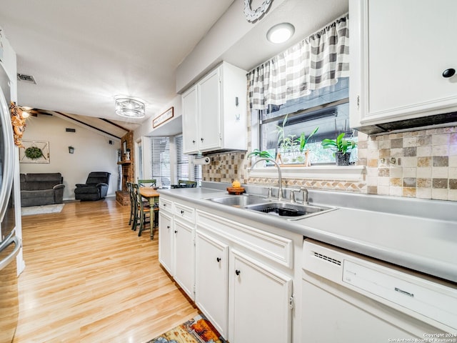 kitchen with white cabinetry, backsplash, light wood-type flooring, white dishwasher, and sink