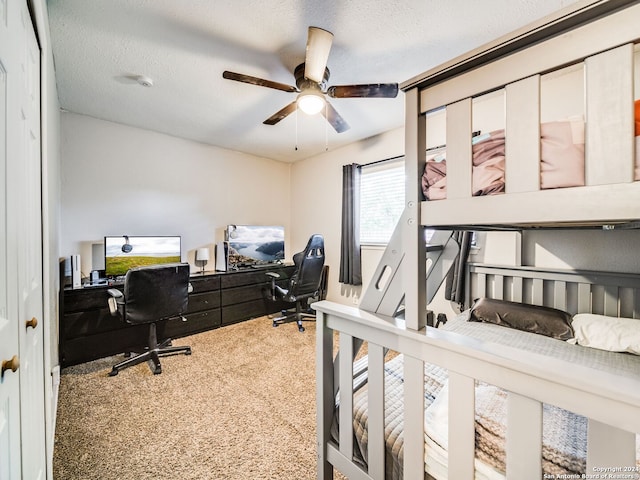 carpeted bedroom with ceiling fan and a textured ceiling