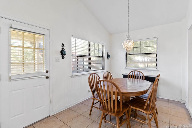 dining space featuring light tile patterned floors, a chandelier, and high vaulted ceiling