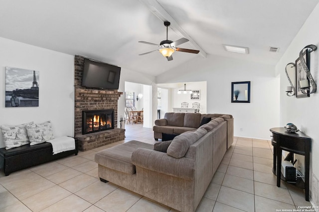 living room featuring lofted ceiling with beams, ceiling fan, light tile patterned floors, and a brick fireplace